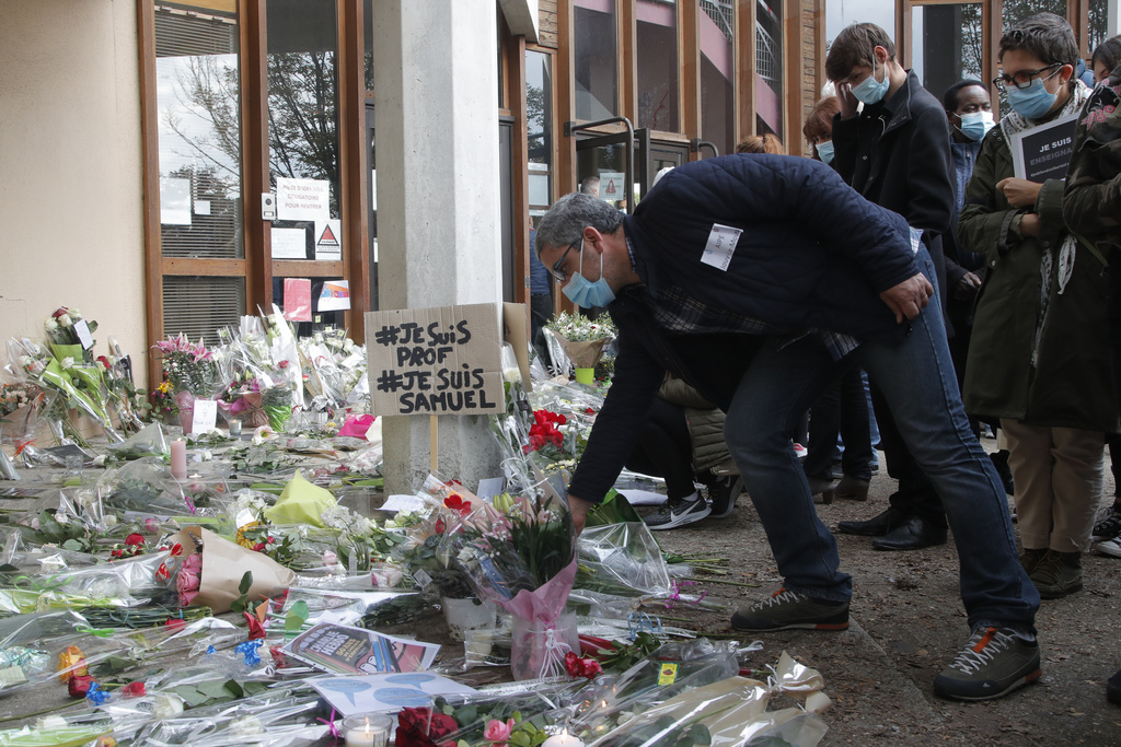 Les hommages fleurissent devant le bâtiment scolaire où enseignait le professeur qui a été lâchement tué.