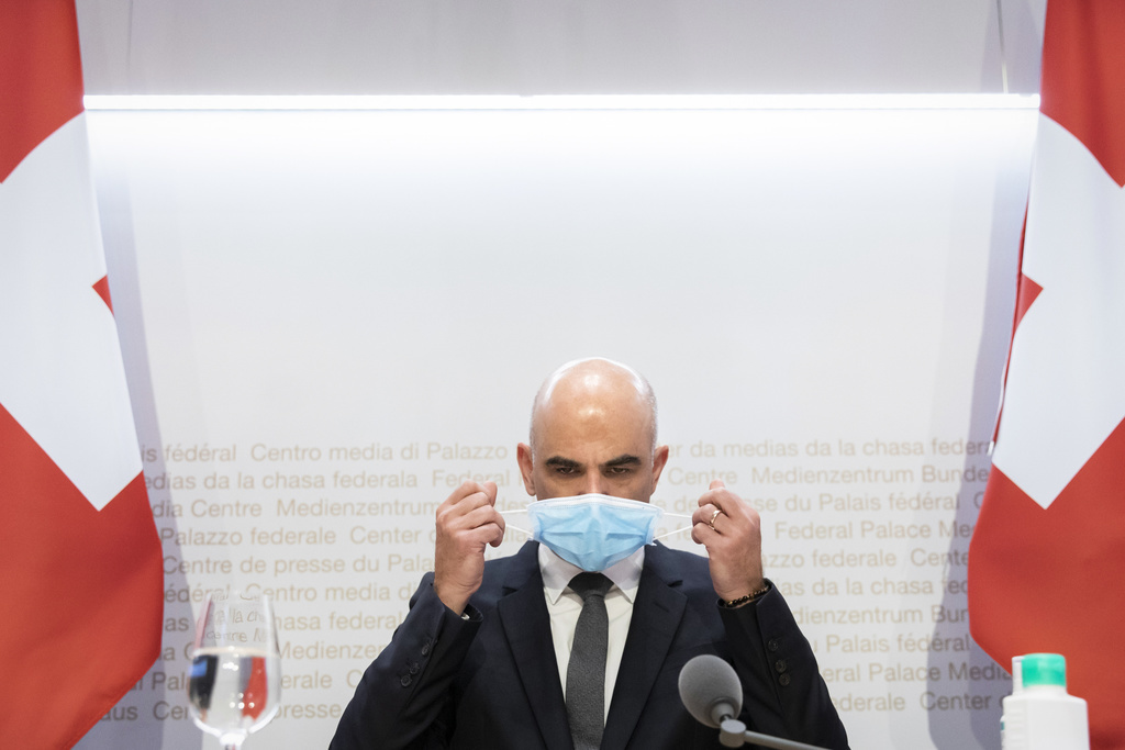 Bundesrat Alain Berset legt seine Maske ab, kurz vor Beginn einer Medienkonferenz des Bundesrates zur aktuellen Lage im Zusammenhang mit dem Coronavirus, am Mittwoch, 6. Januar 2021, in Bern. (KEYSTONE/Peter Klaunzer)