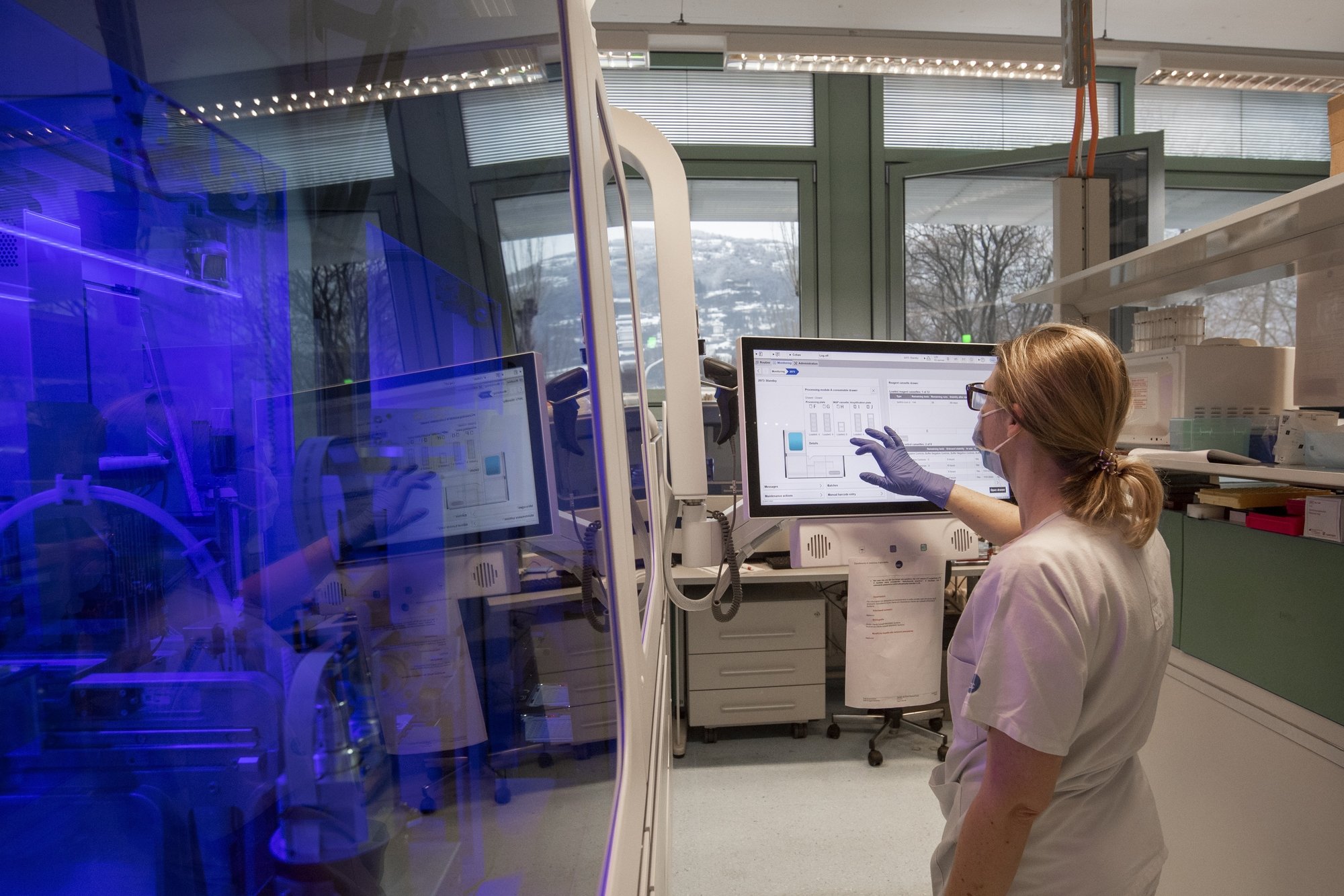 Une laborantine utilise un système d'analyse COBAS pour détecter des mutations du coronavirus dans des tests PCR, au laboratoire cantonal tessinois, à Bellinzone.
