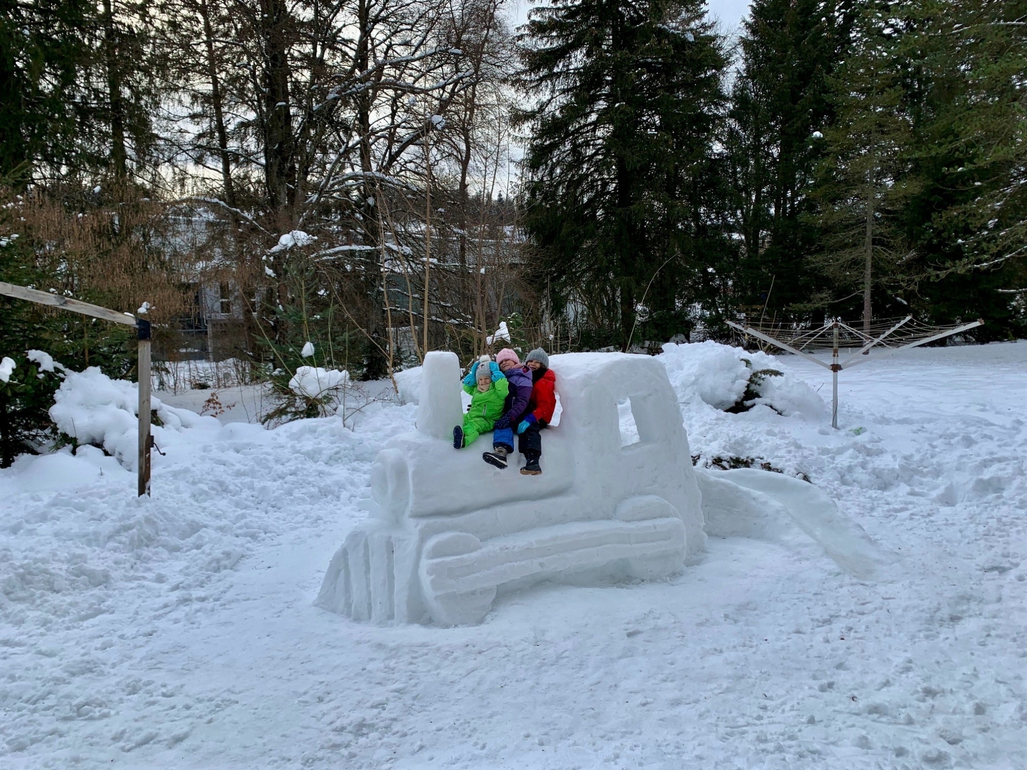 Des voyageurs ravis sur un petit train et son toboggan.