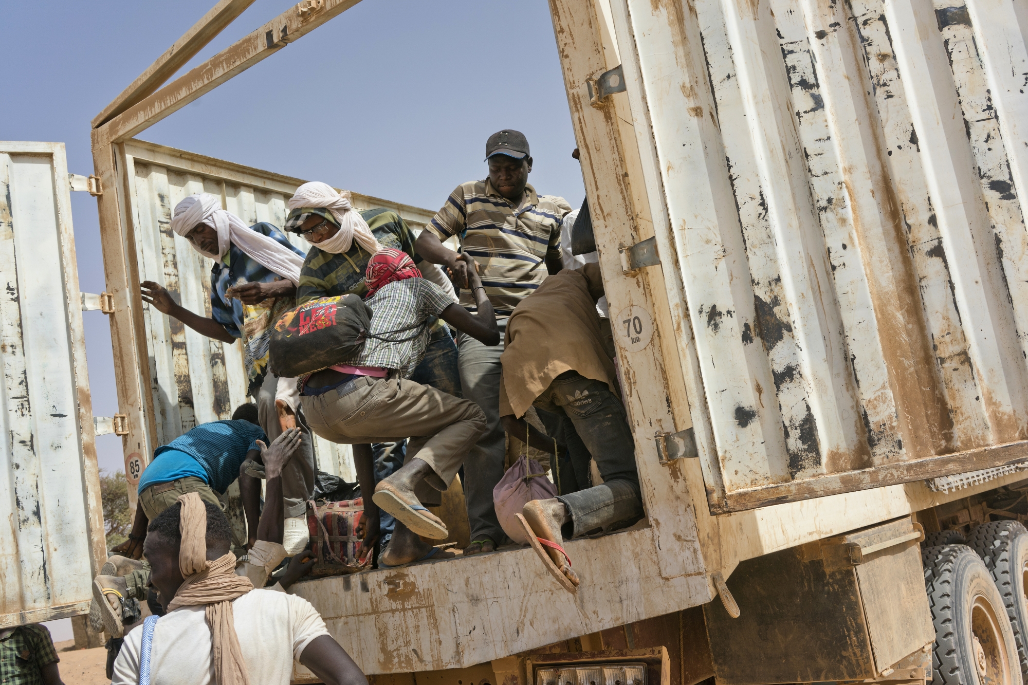 Migrants climb into a truck to head north into Algeria at the Assamaka border post in northern Niger on Sunday, June 3, 2018. The International Organization for Migration has estimated that for every migrant known to have died crossing the Mediterranean, as many as two are lost in the desert. (AP Photo/Jerome Delay)