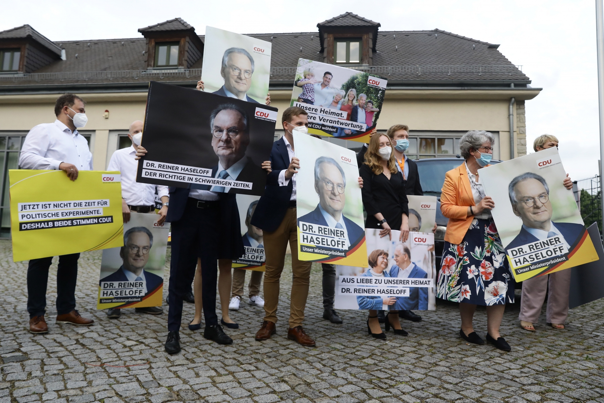 epa09251835 Supporters hold posters with the image of the leading candidate Reiner Haseloff at the election result party of the German Christian Democratic Party (CDU) following the Saxony-Anhalt state elections in Magdeburg, Germany, 06 June 2021. The regional election in Germany's federal state of Saxony-Anhalt is the last before general elections in September and is considered a trend indicator.  EPA/FILIP SINGER Le Nouvelliste