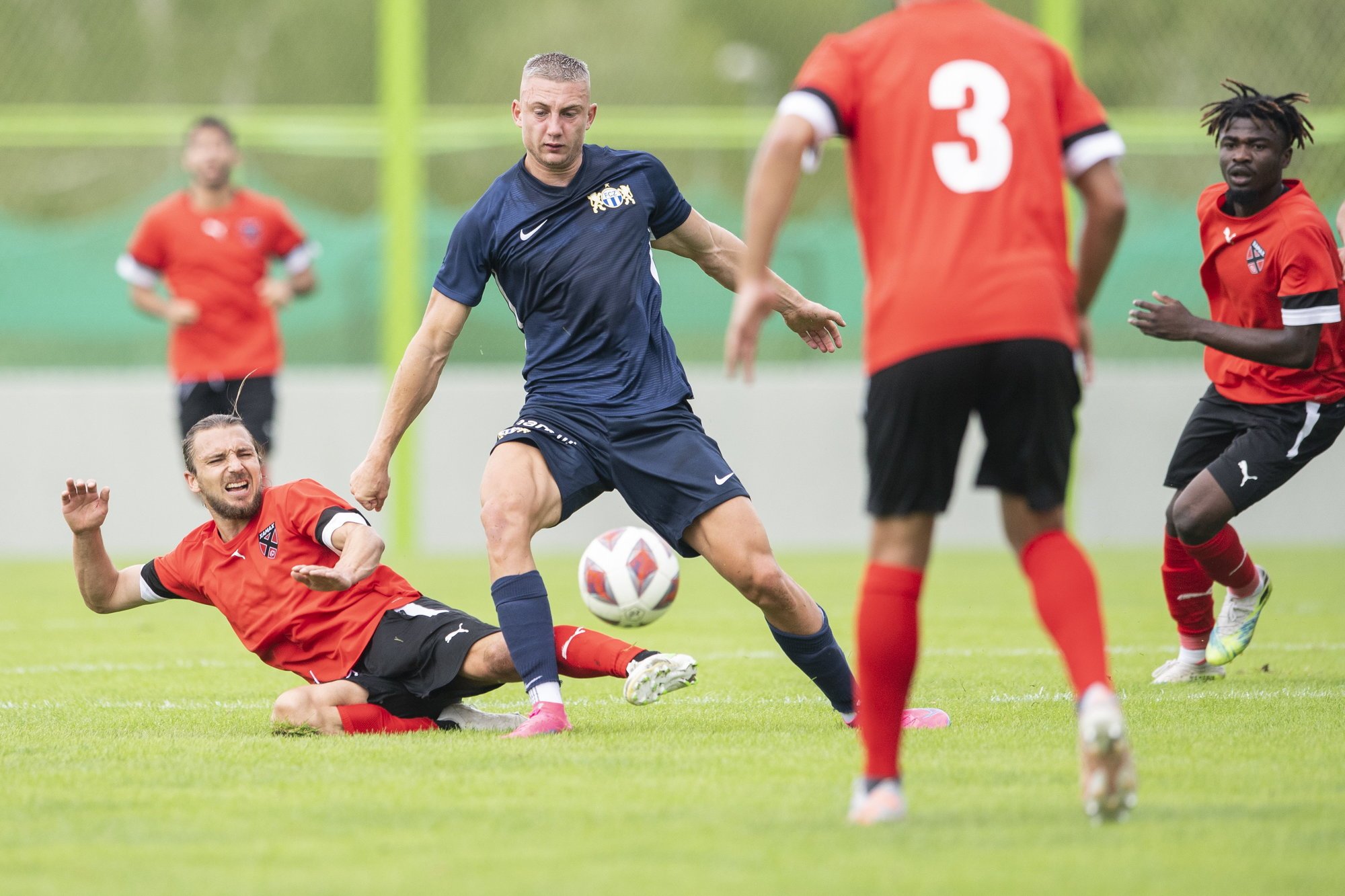 Blaz Kramer (en bleu),  taclé par le Xamaxien Liridon Berisha, a inscrit le seul but zurichois du match. Les Neuchâtelois en ont marqué quatre!. (KEYSTONE/Ennio Leanza)