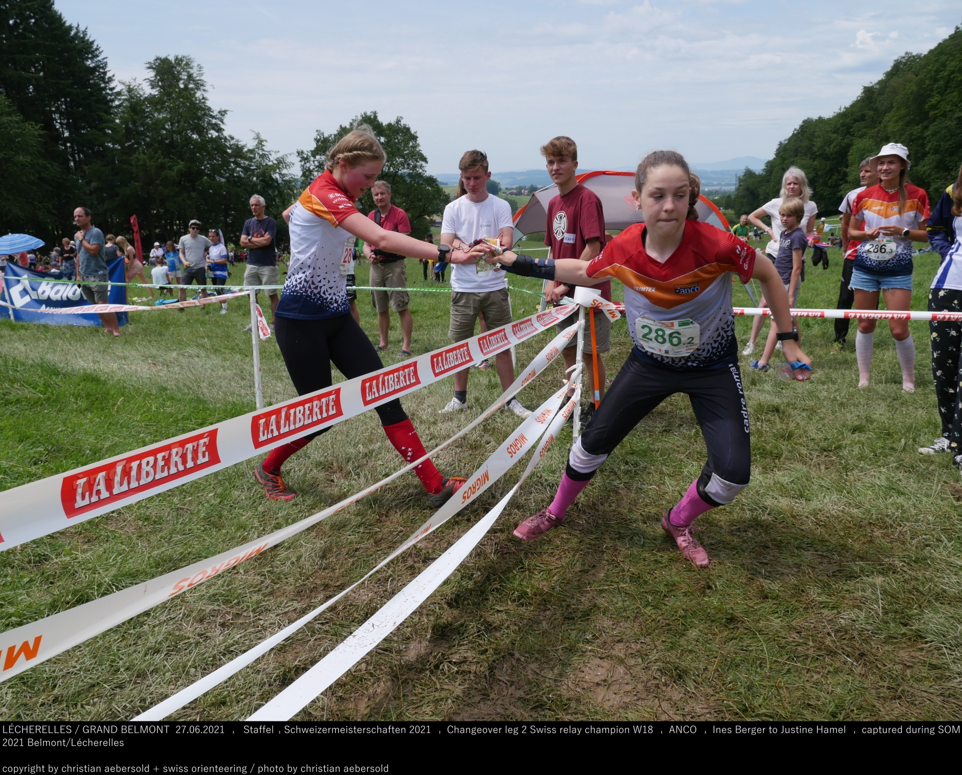 Inès Berger (gauche) passe le témoin à Justine Hamel (droite) lors du relais des championnats de Suisse d'orientation.