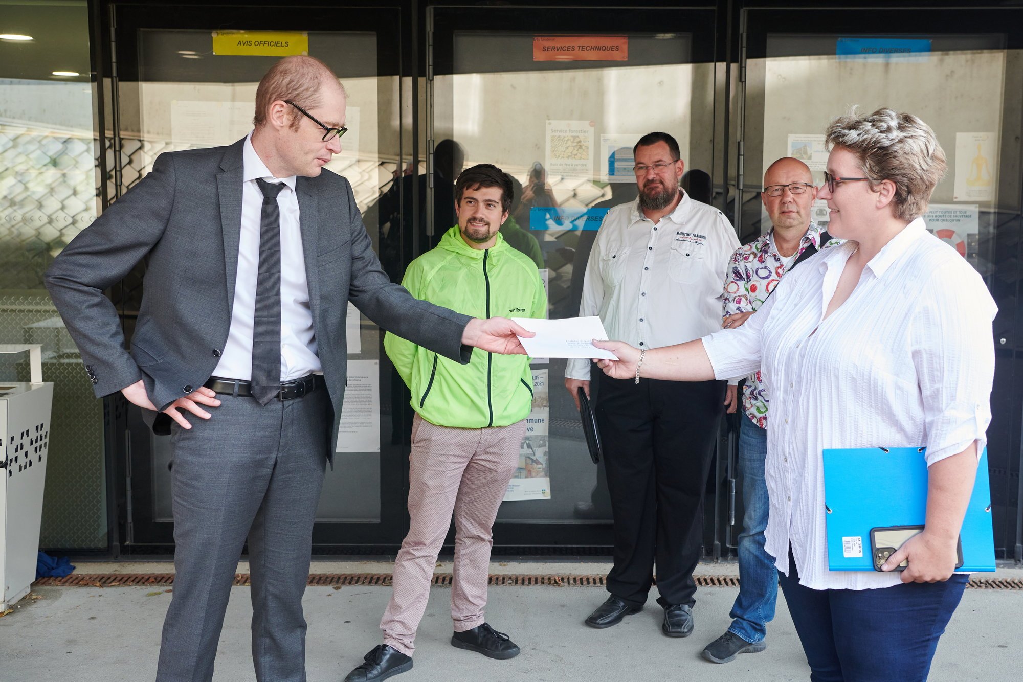 En tête de la délégation vert’libérale landeronaise, Jessica Muriset remet le texte du lancement de l’initiative au président de commune Frédéric Matthey.