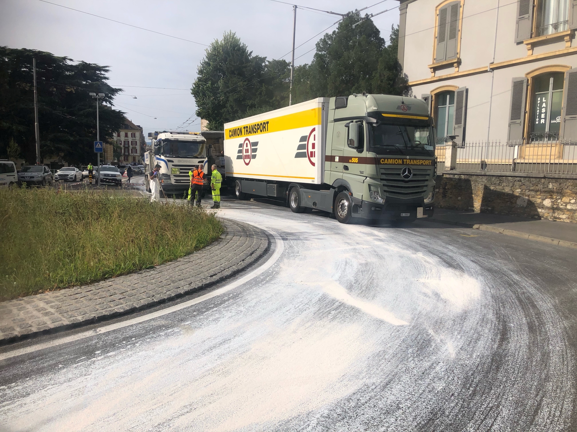 Des camions bloquent, peu avant midi, l'accès au centre-ville de Neuchâtel, tandis que de la peinture blanche a été répandue sur la route.