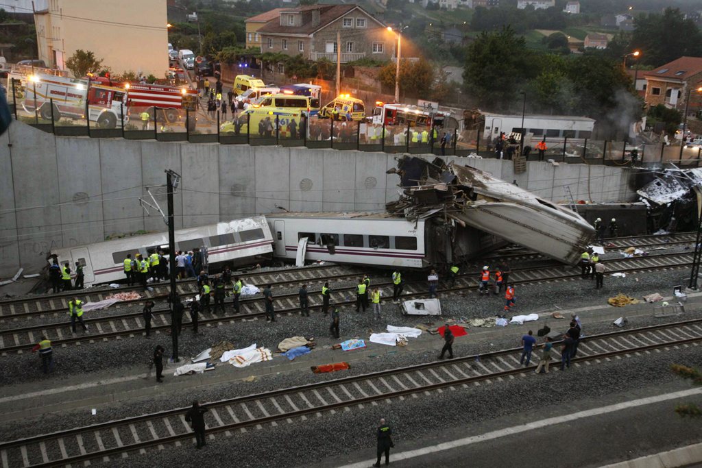 Emergency personnel respond to the scene of a train derailment in Santiago de Compostela, Spain, on Wednesday, July 24, 2013. A train derailed in northwestern Spain on Wednesday night, toppling passenger cars on their sides and leaving at least one torn open as smoke rose into the air. Dozens were feared dead, with possibly even more injured. (AP Photo/ El correo Gallego/Antonio Hernandez)