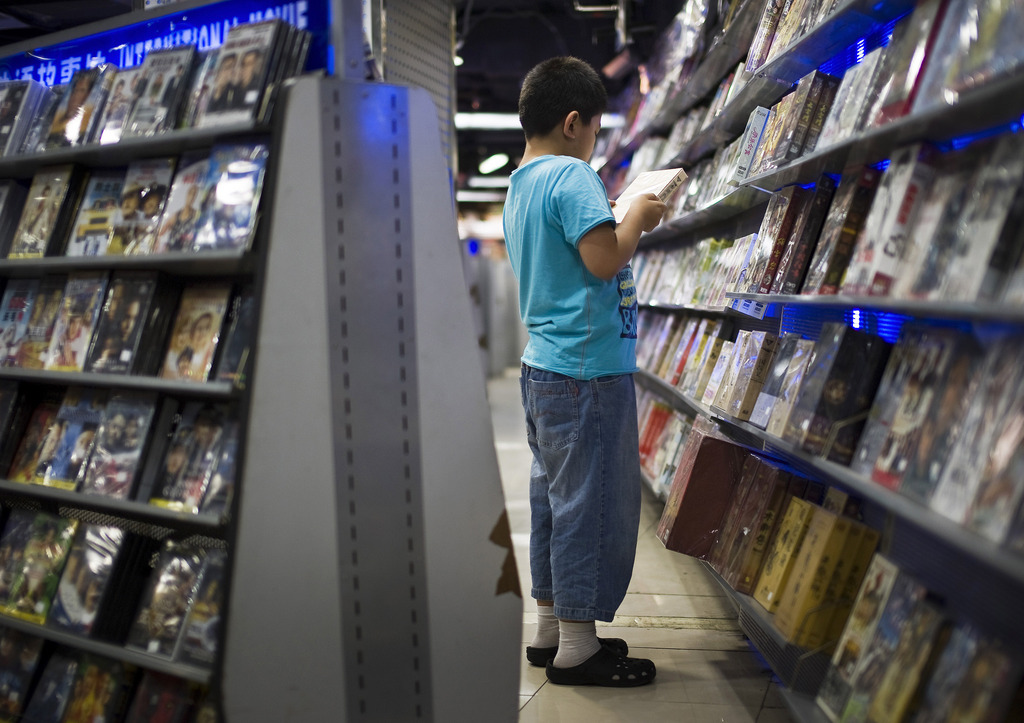 A Chinese boy looks at a movie DVD at a music shop in Beijing, China, Thursday, Aug. 13, 2009. China said Thursday it might appeal a World Trade Organization ruling that told Beijing to ease restrictions on imported movies, music and books in its latest trade dispute with Washington. (AP Photo/Andy Wong)