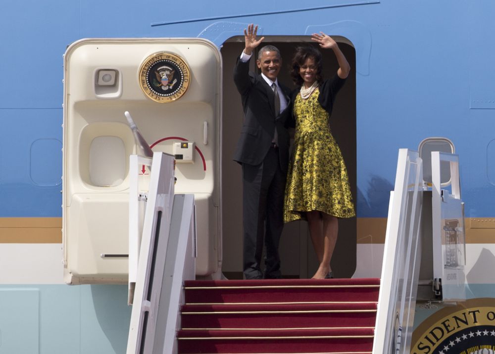 U.S. President Barack Obama and First Lady Michelle Obama wave as they board Air Force One to depart for South Africa, in Dakar, Senegal, Friday, June 28, 2013. President Obama is receiving the embrace you might expect for a long-lost son on his return to his father's home continent, even as he has yet to leave a lasting policy legacy for Africa on the scale of his two predecessors.(AP Photo/Rebecca Blackwell)