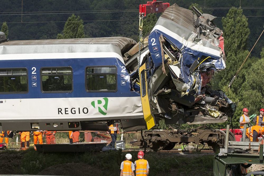 Swiss Federal Railways employees lift one of the trains after the collision, in Granges-pres-Marnand in Western Switzerland, Tuesday, July 30, 2013. One of the train driver died and several passengers were injured in the accident that caused disruption of traffics to the track section between Moudon and Payerne. (KEYSTONE/Salvatore Di Nolfi)