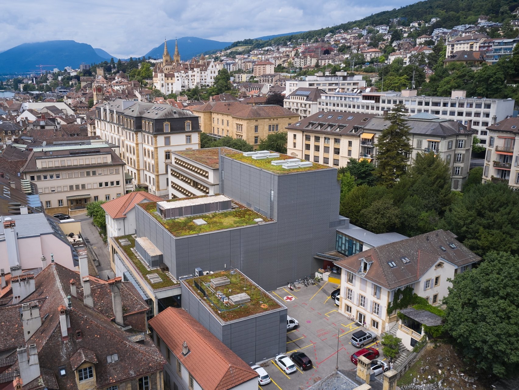 Cette vue aérienne montre l'ancien bâtiment (en bas à droite) où se trouvent les bureaux du théâtre du Passage, ainsi que les nouveaux bâtiments (avec les toits végétalisés), qui abritent la petite salle (en bas) et la grande salle.