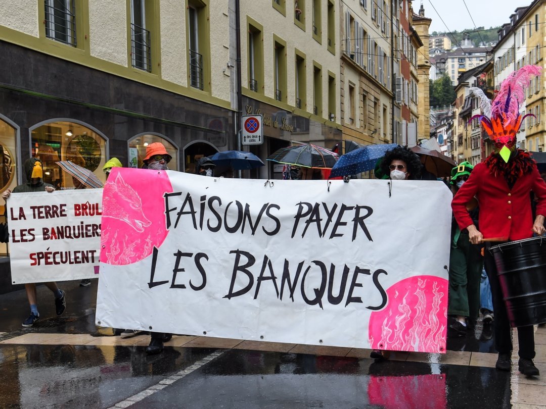 Munis de leur banderole réalisée sur le verso d'une publicité "empruntée" à une grande enseigne, les manifestants anti-banquiers ont bruyamment défilé dans les rues de Neuchâtel.