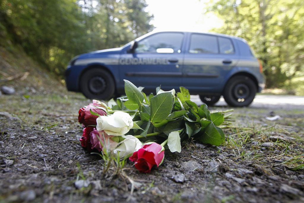 FILE - In this Sept. 8, 2012 file photo flowers are seen at the crime scene where four people have been shot to death in a British-registered car, in a forest in the Alps, near Chevaline, French Alps. The young sisters who survived the mysterious shootings in the French Alps are the only known witnesses to the crime, and experts say 4-year-old Zeena and 7-year-old Zaina could provide crucial help to the investigation into a killing that remains a mystery several days later, if handled carefully. (AP Photo/Laurent Cipriani, File)