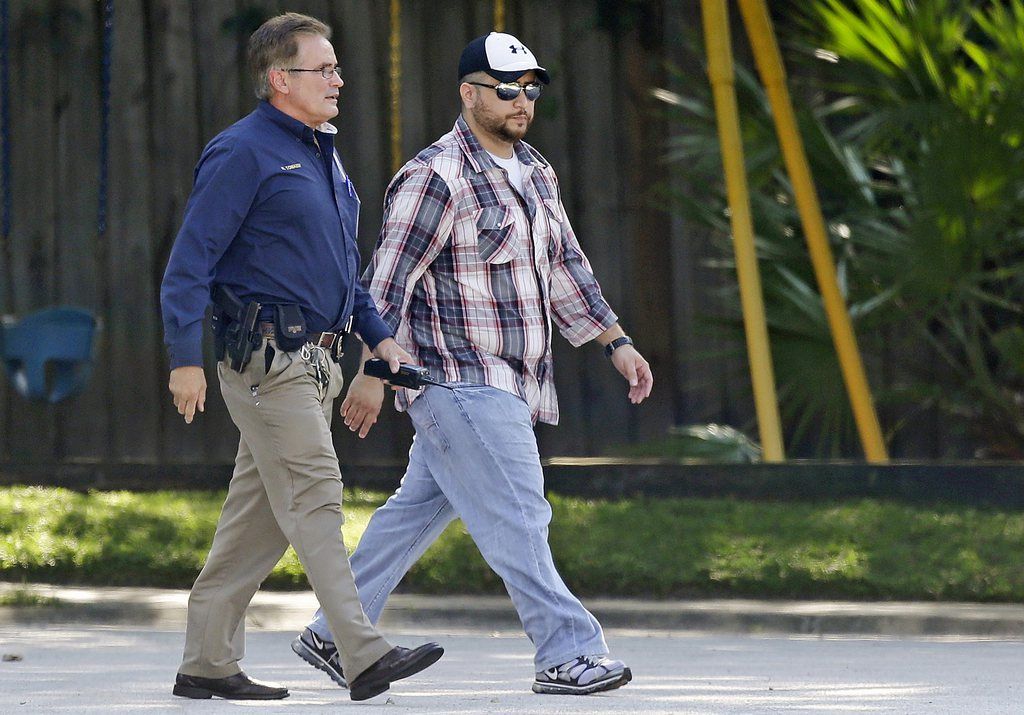 George Zimmerman, right, is escorted to a home by a Lake Mary police officer, Monday, Sept. 9, 2013, in Lake Mary, Fla., after a domestic incident in the neighborhood where Zimmerman and his wife Shellie had lived during his murder trial. Zimmerman's wife says on a 911 call that her estranged husband punched her father in the nose, grabbed an iPad out of her hand and smashed it and threatened them both with a gun. Zimmerman was recently found not guilty for the 2012 shooting death of Trayvon Martin. (AP Photo/John Raoux)