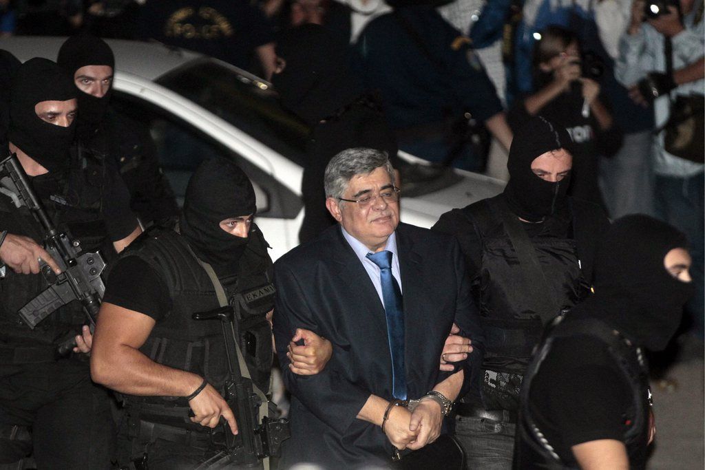 epa03892943 Anti-terror police officers escort Nikos Michaloliakos, leader of the ultra-right-wing Golden Dawn party at the courthouse in Athens, Greece, 02 October 2013.  Golden Dawn lawmaker Yannis Lagos (not pictured) is the only one of the four party lawmakers who will remain in custody pending trial according to investigating magistrates. All MPs are facing the same charges, however evidence on Lagos' involvement in Pavlos Fyssas murder on 17 September in Keratsini are alleged to be strong.  EPA/ORESTIS PANAGIOTOU