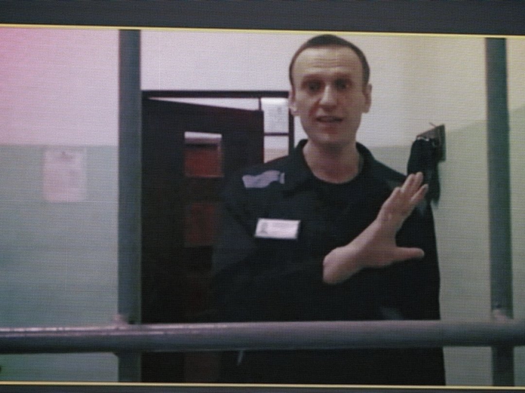 Russian opposition leader Alexei Navalny, seen on a TV screen as he appears in a video link provided by the Russian Federal Penitentiary Service from the colony in Melekhovo, Vladimir region, during a hearing at the Russian Supreme Court in Moscow, Russia, on Wednesday, Aug. 23, 2023. Navalny, who has been behind bars since 2021, has filed a lawsuit contesting prison regulations that, according to him, bar him from using prison jargon under the threat of solitary confinement. Russia's Supreme Court on Wednesday rejected the politician's complaint. (AP Photo/Alexander Zemlianichenko)