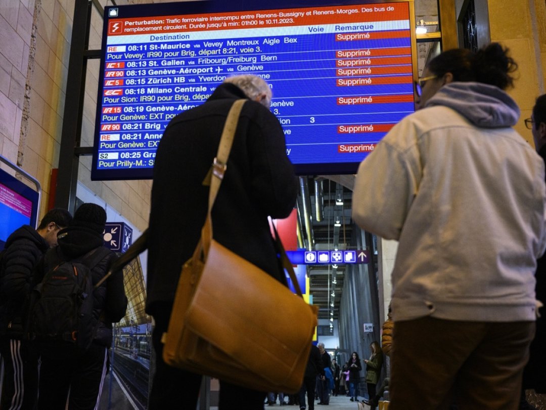 Des voyageurs observent le panneau des horaires de trains avec la mention ce jeudi 9 novembre 2023 à la gare de Lausanne.