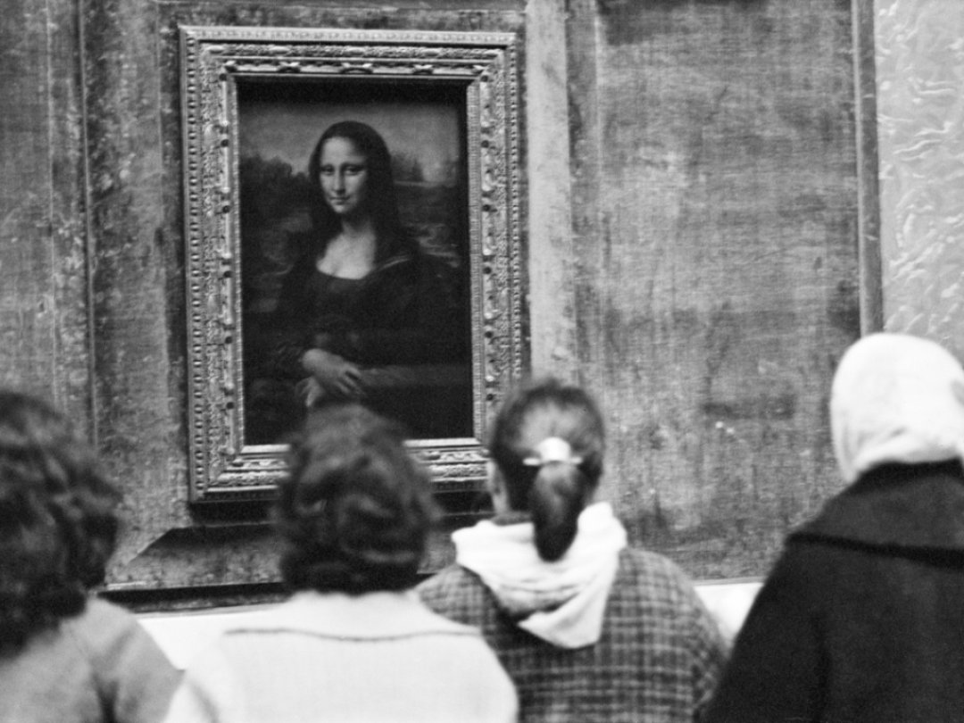 Des visiteurs regardent la Joconde de Léonard de Vinci au Musée du Louvre à Paris (archives).