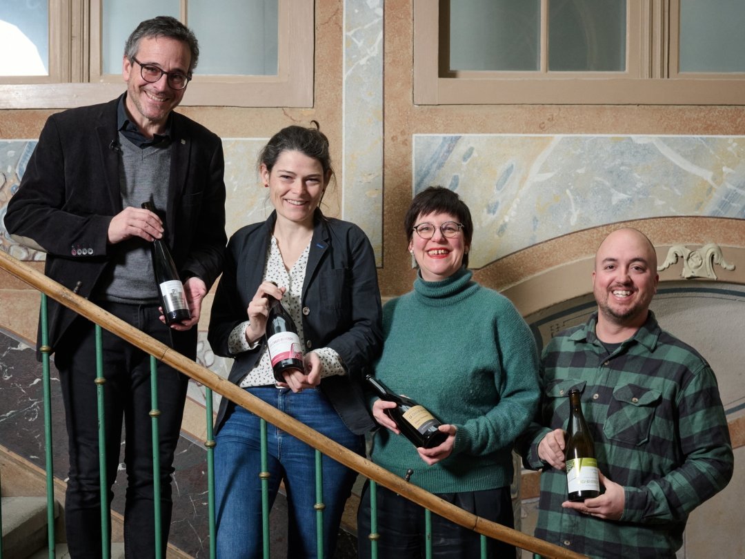 La cuvée 2024 présentée par (de g. à d.) Théo Huguenin-Elie, Laure Houlmann (gestionnaire des vins de la Ville), Sylvie Pipoz (déléguée à la valorisation du patrimoine) et Benoît de Montmollin.