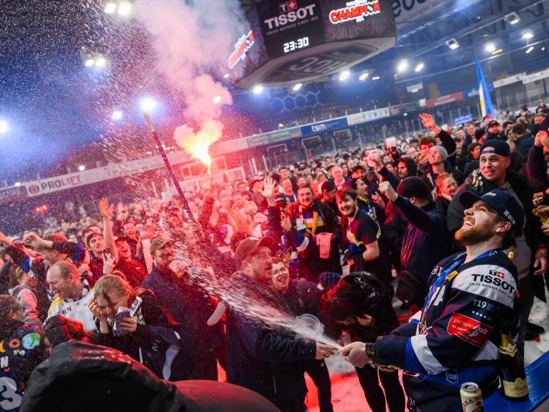 Joueur du HCC, Anthony Huguenin célèbre avec les supporters ayant envahi la patinoire: les Abeilles sont championnes de Swiss League!