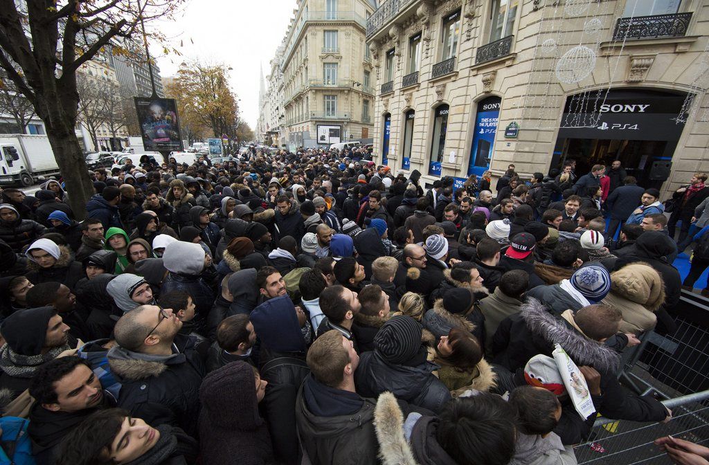 epa03969936 Hundreds of people queue outside the Sony store to purchase Sony's new flagship video-game console, the Playstation 4 (PS4), during the official PS4 launch at the Sony store in Paris, France, 29 November 2013.  EPA/IAN LANGSDON