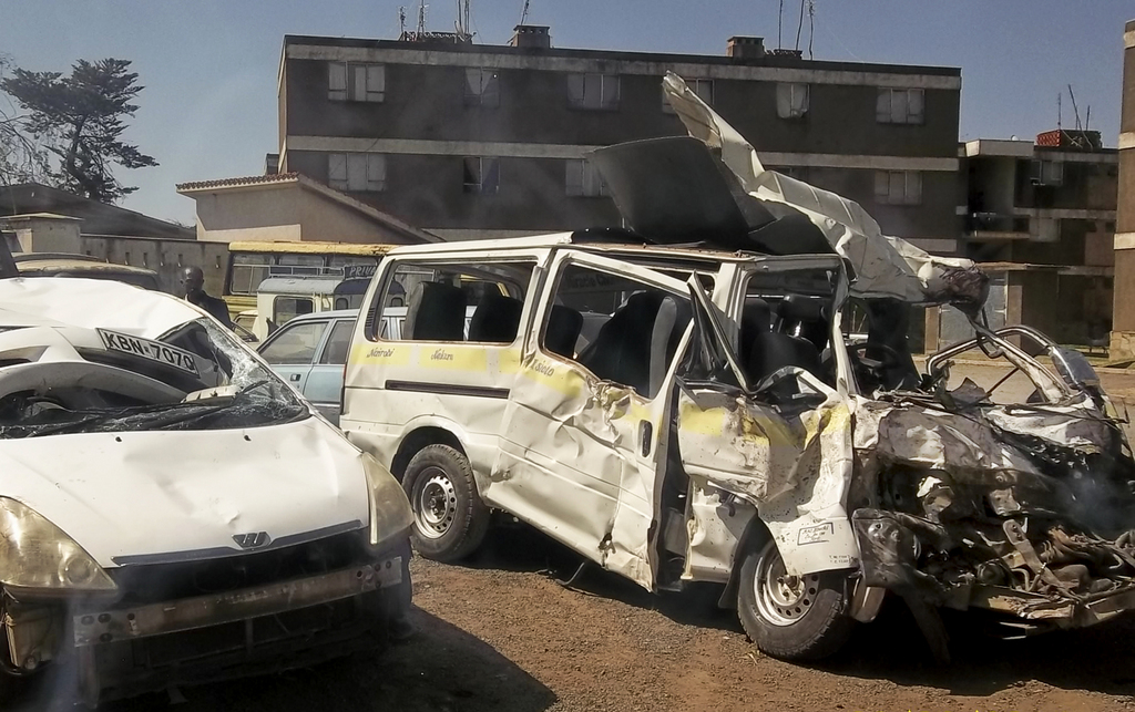 In this Feb. 22, 2014 photo, the private minibus, right, in which a Norwegian student and the driver were killed and a number of other students seriously injured, according to police, sits at a police station in Nanyuki in Kenya. The accident took place at the geographical Equator line, a spot which is a favourite for visiting tourists to Nanyuki town, and occurred when the lorry attempted to overtake a saloon car but hit it and then lost control and crashed into the private minibus, according to police at the scene. (AP Photo)