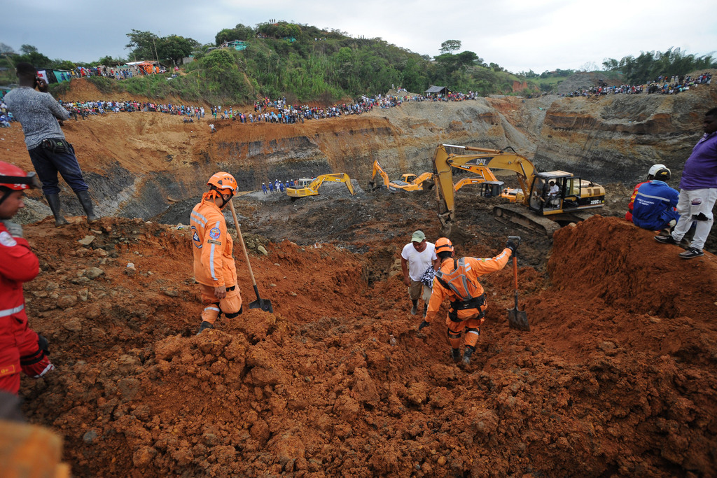 People watch for the search of survivors at a collapsed illegal gold mine in Santander de Quilichao, southern Colombia, Thursday, May 1, 2014.  Colombian rescuers on Thursday hunted for more than a dozen people feared trapped beneath debris left by in the collapse of an illegal gold mine that killed at least three people, officials said. (AP Photo/Oswaldo Paez, El Pais)