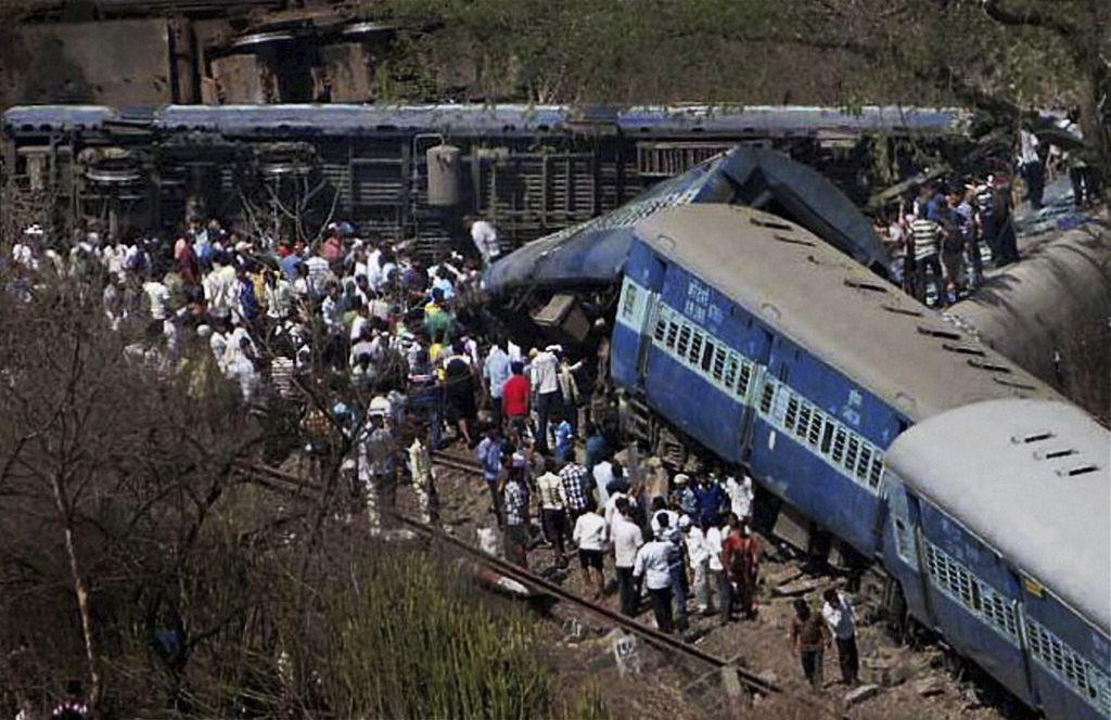 People gather around a passenger train that derailed near Roha station, 110 kilometers (70 miles) south of Mumbai, Maharashtra state, India, Sunday, May 4, 2014. The cause of the accident was not immediately known. (AP Photo)