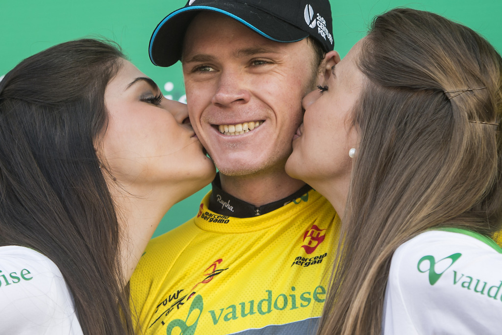 Winner of the 68th Tour de Romandie British Christopher Froome of team Sky Procycling is kissed by two hostess with his yellow jersey on the podium during the 5th and last stage, a 18,5 km race against the clock, at the 68th Tour de Romandie UCI ProTour cycling race, in the Stadium Maladiere in Neuchatel, Switzerland, Sunday, May 4, 2014. (KEYSTONE/Jean-Christophe Bott)