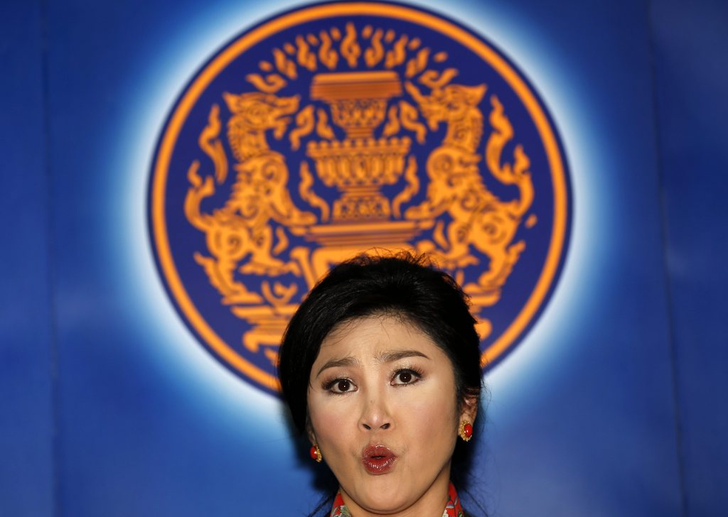 epa04194738 Thai caretaker Prime Minister Yingluck Shinawatra speaks during a nationwide televised press conference after she was removed from office at the Office of the Permanent Secretary for Defense in Bangkok, Thailand, 07 May 2014. Thai caretaker Prime Minister Yingluck Shinawatra was sacked on 07 May 2014 by a Constitutional Court ruling that she illegally transferred a civil servant three years ago. The guilty verdict also removes nine of her cabinet members from office. The remaining 26 cabinet members will continue in a caretaker capacity until a new government takes office.  EPA/RUNGROJ YONGRIT