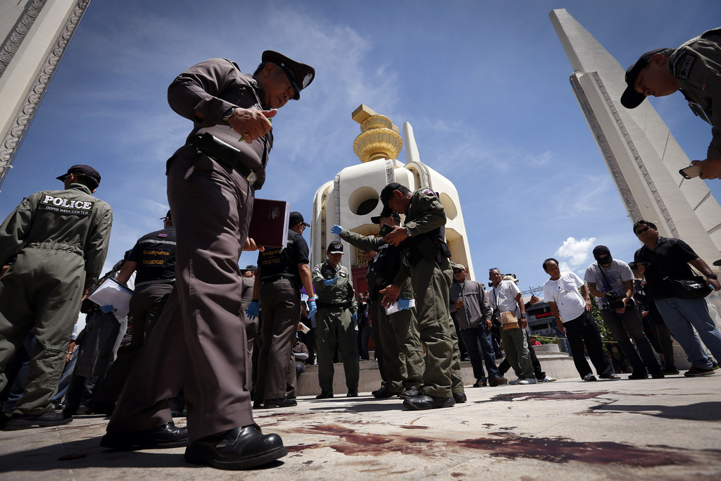 Thai police investigate following an overnight shooting attack at Democracy Monument in Bangkok, Thailand, Thursday, May 15, 2014. Explosions and an overnight shooting attack on opposition demonstrators in Thailand's capital killed at least two people Thursday, the latest spasm of violence to hit Bangkok since protesters launched a campaign to oust the government six months ago. (AP Photo/Vincent Thian)