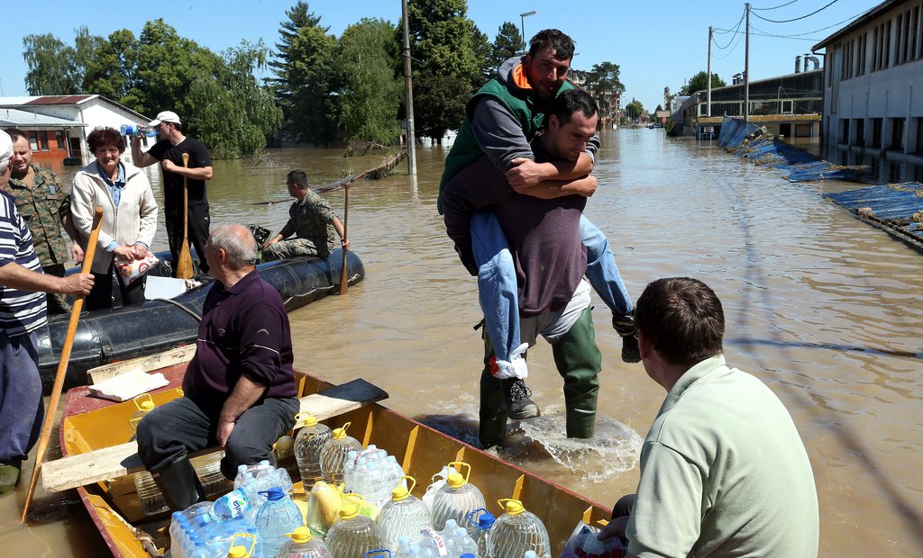 epa04213912 People are evacuated from their homes after flooding in the town of Bosanski Samac, 250 km from Sarajevo, northern Bosnia and Herzegovina, 19 May 2014. A state of emergency has been declared in Bosnia and Herzegovina due to severe floods caused by rain falling for several days. The heavy flooding and landslides in Bosnia, Croatia and Serbia that have destroyed homes and killed a number of people over the past week may, experts warn, have another potentially deadly effect - spreading landmines. Mine actions centres (MAC) in the three countries are working on a joint team to assess the threat the flooding may have on the hundreds of thousands of landmines planted 20 years ago during wars in the former Yugoslavia.  EPA/FEHIM DEMIR