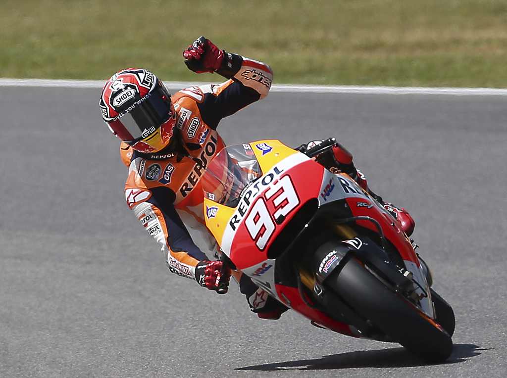 Honda rider Marc Marquez, of Spain, waves to fans after getting the pole position for Sunday's Italian Moto GP, at the Mugello race circuit, in Scarperia, Italy, Saturday, May 31, 2014. (AP Photo/Antonio Calanni)