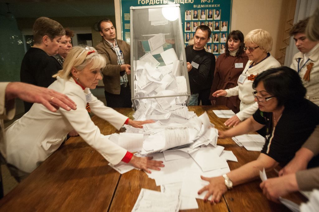 Members of election committee empty a ballot box after voting closed at a polling station in Donetsk, Ukraine, Sunday, May 11, 2014. Voters in two insurgent Ukrainian regions cast ballots Sunday on whether to declare their areas sovereign republics, a move denounced by the central government and likely to deepen the turmoil in the largely Russian-speaking east. (AP Photo/Evgeniy Maloletka)