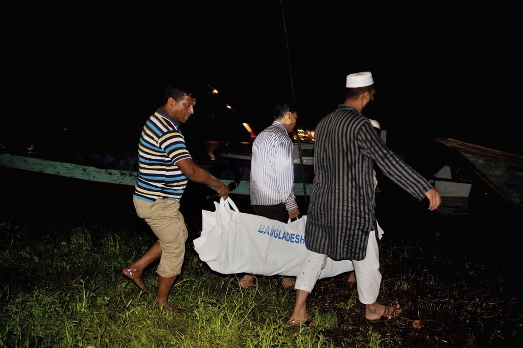 Bangladeshi men carry the body of a victim of a ferry that capsized in Meghna River at Munshiganj district, in Bangladesh, Friday, May 16, 2014. Rescuers have recovered at least 22 bodies after a ferry capsized during a storm in a river in central Bangladesh, officials said Friday. (AP Photo/Suvra Kanti Das)