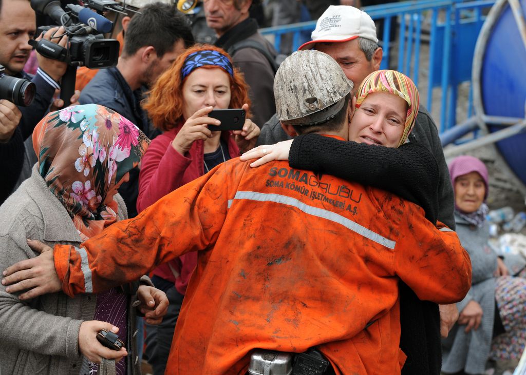 Family members hug a rescued miner outside the coal mine in Soma, Turkey, Wednesday, May 14, 2014.  Rescuers desperately raced against time to reach more than 200 miners still trapped underground Wednesday after an explosion and fire at the coal mine killed at least 238 workers, Erdogan said in Soma.(AP Photo/Depo Photos