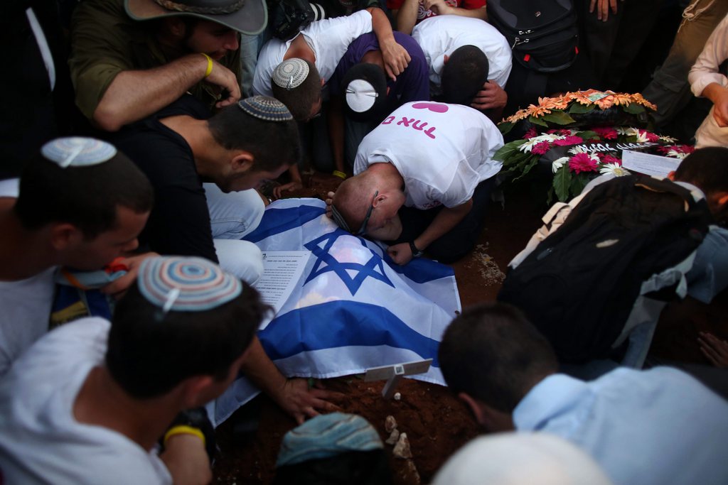 epa04294374 Friends of Gil-Ad Shaer, one the three Israeli teens who were abducted and killed, mourn on his grave during his funeral in the Israeli city of Modi'in, 01 July 2014. Tens of thousands of mourners joined in an outpouring of national grief at the burial of the three Israeli teenagers whose kidnapping and killing Israel blamed on the Palestinian Islamist group Hamas. The Islamist group has neither confirmed nor denied involvement in the disappearance of the students as they hitchhiked near a Jewish settlement on 12 June.  EPA/ABIR SULTAN