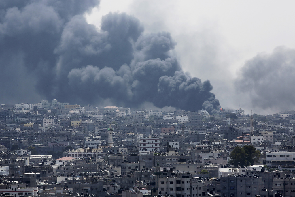 Smoke rises after an Israeli missile hit Shajaiyeh neighborhood in Gaza City, northern Gaza Strip, Sunday, July 20, 2014. Hundreds of panicked residents have fled the neighborhood which they say has come under heavy tank fire from Israeli forces. Some reported seeing dead and wounded in the streets, with ambulances unable to reach the area. Israel widened its ground offensive early Sunday, sending more troops into the Hamas-ruled territory to destroy tunnels used by the Islamic militants to try to sneak into Israel. (AP Photo/Adel Hana)