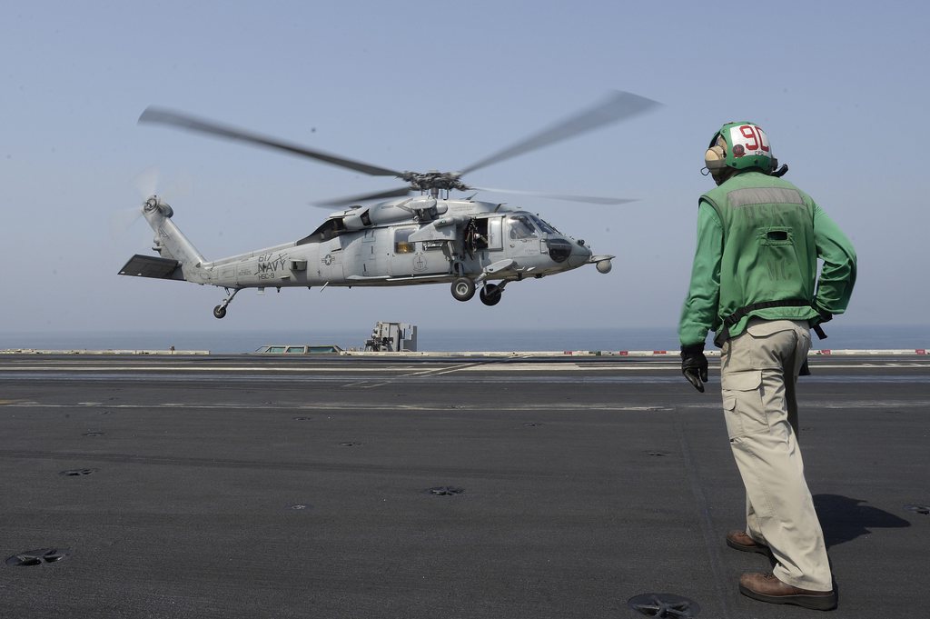 epa04355731 A US Navy helicopter launches for operations from the aircraft carrier USS George H.W. Bush in the Persian Gulf waters 15 August 2014.  Aircrafts from the carrier are part of the US military aircrafts conducting strikes against the Islamic State extremists in northern Iraq to halt their advance and protect US personnel in the Kurdish region.  EPA/MAZEN MAHDI