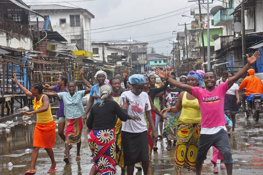 People celebrate on the streets outside of West Point, which has been closed in by Liberian security forces to stop all movement the past week in a attempt to control the Ebola outbreak in Monrovia, Liberia, Saturday, Aug. 30, 2014. Liberia says it will open up a slum in its capital where thousands of people were barricaded to contain the spread of Ebola. Information Minister Lewis Brown says lifting the quarantine Saturday morning will not mean there is no Ebola in the West Point Slum. (AP Photo/Abbas Dulleh)