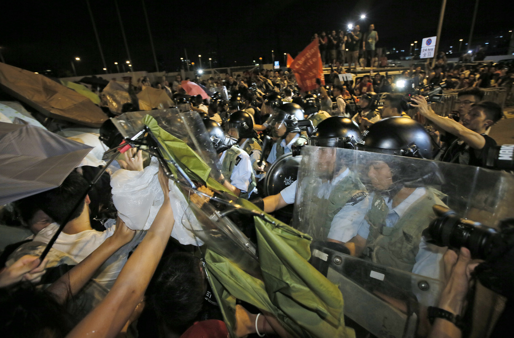 Protesters scuffle with riot policemen after young pro-democracy activists forced their way into Hong Kong government headquarters  during a demonstration in Hong Kong, early on Saturday, Sept. 27, 2014. The scenes of disorder came at the end of a weeklong strike by students demanding China?s communist leaders allow residents to directly elect a leader of their own choosing in 2017. (AP Photo/Vincent Yu)