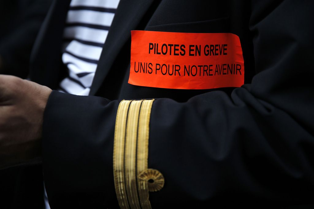 Air France pilots attend a demonstration in Paris, Tuesday, Sept. 23, 2014. France?s prime minister  speaking out against Air France pilots who are striking for an eighth day over the proposed expansion of its low-cost carrier, Transavia. Air France-KLM airline says the strike is costing up to euro20 million  ($25 million) a day. The company is cutting costs to try to stay competitive with budget airlines. About half the airline?s flights have been cancelled. The sticker reads: Pilots on strike. All together for our future (AP Photo/Christophe Ena)
