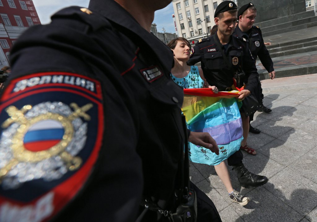 epa03716169 Police officers detain a female member of the LGBT (lesbian, gay, bisexual, and transgender) community, who was trying to participate in a parade in Moscow, Russia, 25 May 2013. Homosexuals gathered to demand respect for people with different sexual preferences.  EPA/SERGEI ILNITSKY