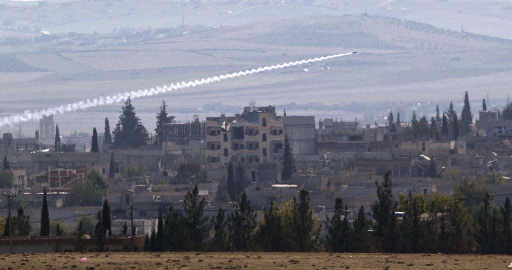 A missile is fired from Islamic State positions in Kobani, seen from a hilltop outside Suruc, on the Turkey-Syria border Thursday, Nov. 6, 2014. Kobani, also known as Ayn Arab, and its surrounding areas, has been under assault by extremists of the Islamic State group since mid-September and is being defended by Kurdish fighters. (AP Photo/Vadim Ghirda)