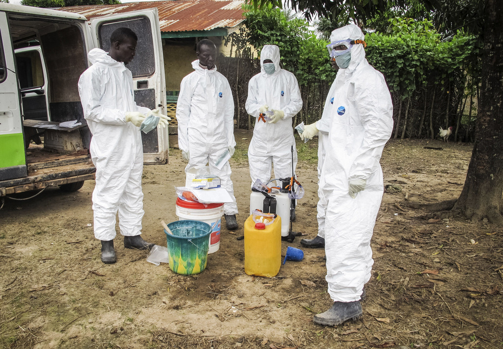 FILE-In this file photo taken on Tuesday, Oct. 21, 2014, health workers wear protective gear before entering the house of a person suspected to have died of the Ebola virus in Port Loko Community situated on the outskirts of Freetown, Sierra Leone.  Sierra Leone?s junior doctors were on strike for a second day Tuesday, Dec. 9, 2014, to demand better care for medical workers who catch Ebola after a spate of recent deaths. (AP Photo/Michael Duff, File)