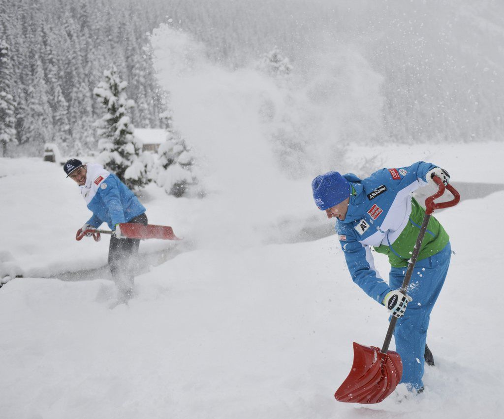 epa04506157 Austrian Alpine ski teammates Max Franz (L) and Romed Baumann shovel snow at each other, in Lake Louise, Alberta, Canada, 27 November 2014. The Men's World Cup Downhill training run was cancelled due to heavy snow.  EPA/MIKE STURK