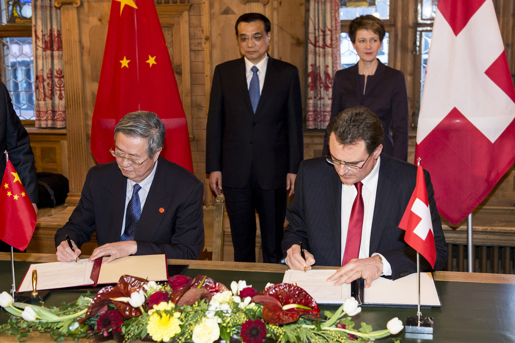 Zhou Xiaochuan, front left, Governor of the People's Bank of China and Thomas Jordan, chairman of the Swiss National Bank (SNB), front right, signe documents in the presence of Li Keqiang, back left, Premier of the People's Republic of China and Swiss President and Justice Minister Simonetta Sommaruga, back right, during a bilateral meeting on the sideline at the 45th Annual Meeting of the World Economic Forum, WEF, in Davos, Switzerland, Wednesday, January 21, 2015. The overarching theme of the Meeting, which takes place from 21 to 24 January, is "The New Global Context". (KEYSTONE/POOL/Jean-Christophe Bott)