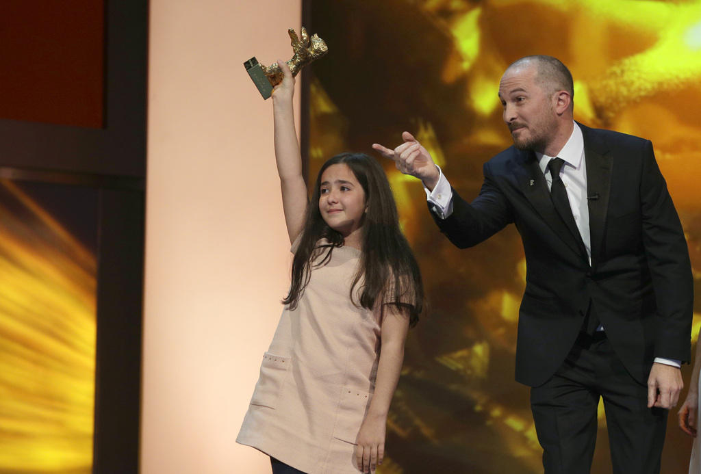 Hana Saeidi, nièce de Jafar Panahi absent à la cérémonie, brandit l'Ours d'or remporté par son oncle pour le film "Taxi".
