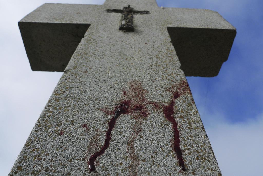A stain of blood is seen on a cross of a grave at a  cemetery where two bodies were found  in Tijuana, Thursday, Oct. 15, 2009. Two bodies were found in the area in what police at the scene said appeared to be revenge killings related to drug trafficking. (AP Photo/Guillermo Arias)