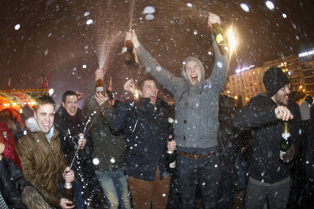 People splash the champagne shortly after midnight for celebrate the New Year, in Geneva, Switzerland, Wednesday, January 1, 2014. (KEYSTONE/Salvatore Di Nolfi)